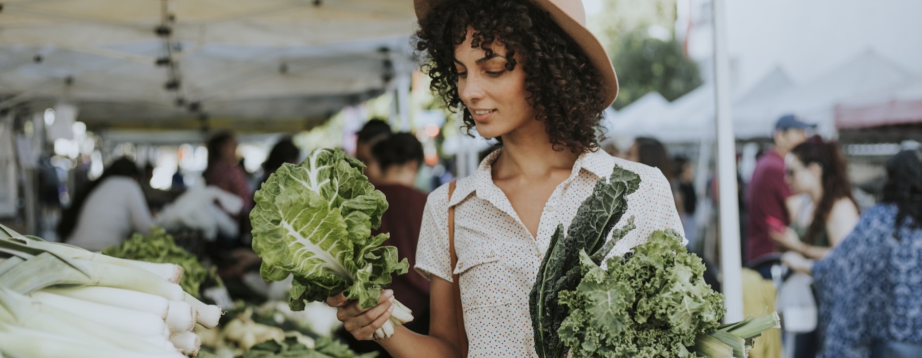 a woman holding a bunch of broccoli